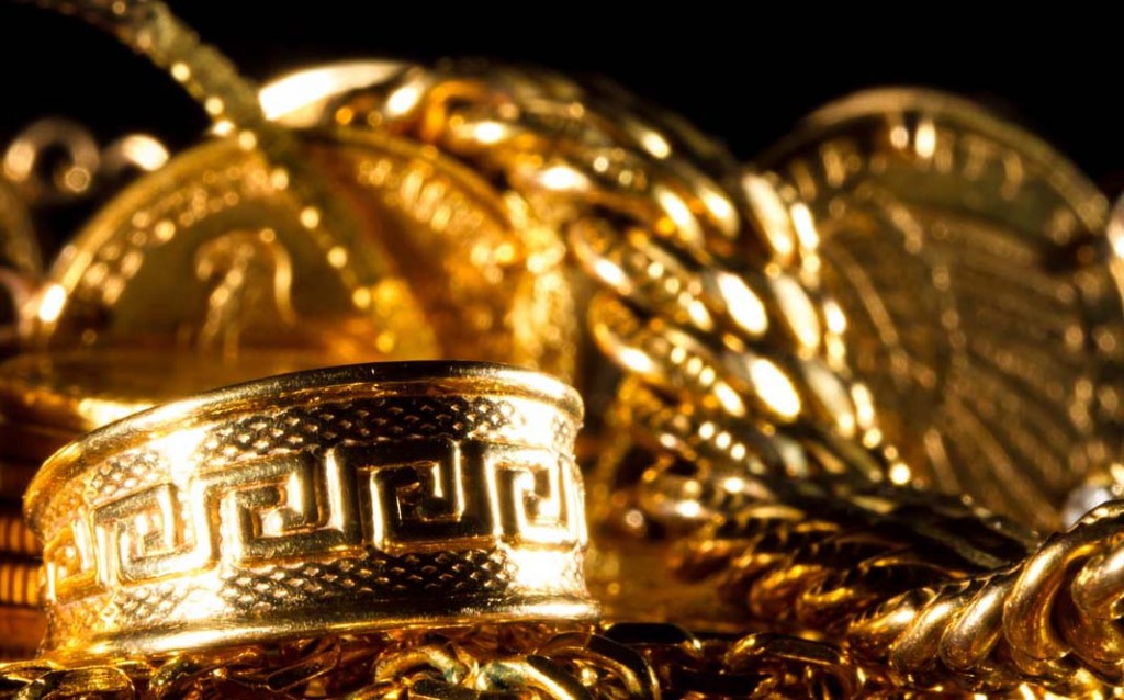 Greek meander ring Jewels and gold coins over dark background